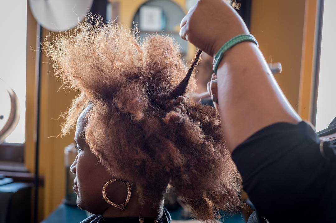 08 maart 2018: Photo and words by @ninarobinsonnyc (Nina Robinson) | Tori Brown, owner of BRE Hair Studio, helps professional women in Louisville, Kentucky find a polished hairstyle uniquely their own. “I think hair is a statement, whatever your ethnicity is. You don't have to be put in a box. I try to encourage my clients to not feel afraid to live out loud," she says. “Every few weeks Ashia Powell, pictured here, comes into Tori’s salon to have her hair detangled, shampooed and conditioned. Then a foaming pomade goes on to add flexibility to her natural coils. Tori wants to strip away the exoticism and mystery often foisted upon African-American women’s hair, along with the stigma. “Hair is hair,” she says. It comes out coarse, medium and fine. It can be straight, curly or kinky. Coils can be tight or loose. Tori’s approach to styling has drawn a loyal following of professional women in Louisville. This photograph is from the #heramerica project Real Womens' Stories Across America produced by Lifetime.”
#PressforProgress #InternationalWomensDay #IWD2018 #WomensHistoryMonth #NatGeoWomen 
